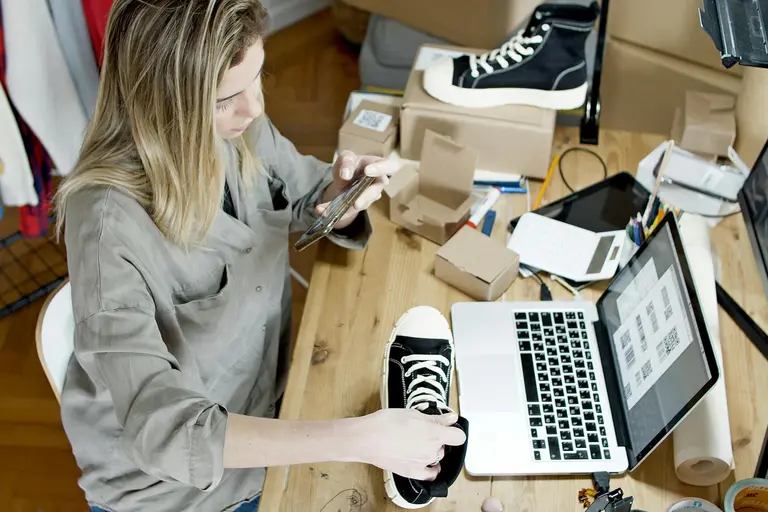 Woman working on listing items for sale on her website